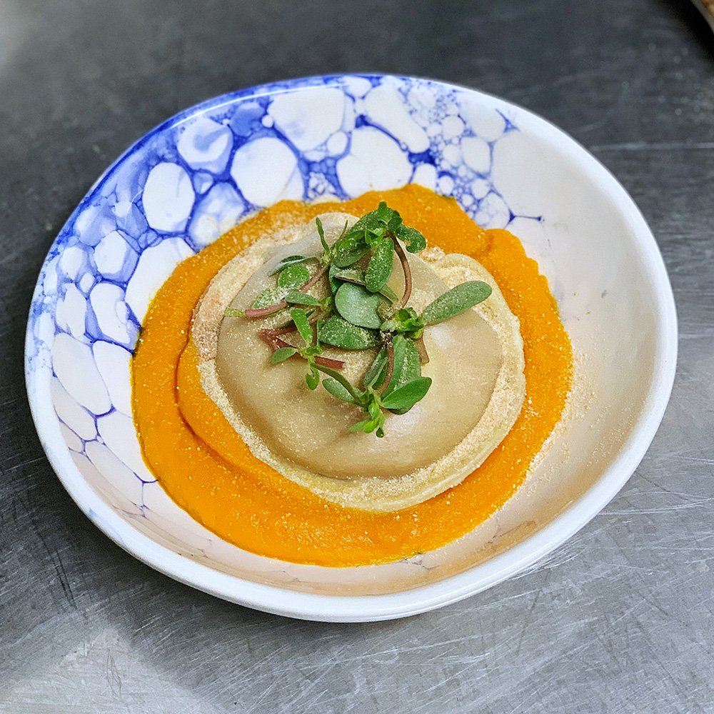 Prato com puré cor de laranja e ervas frescas
