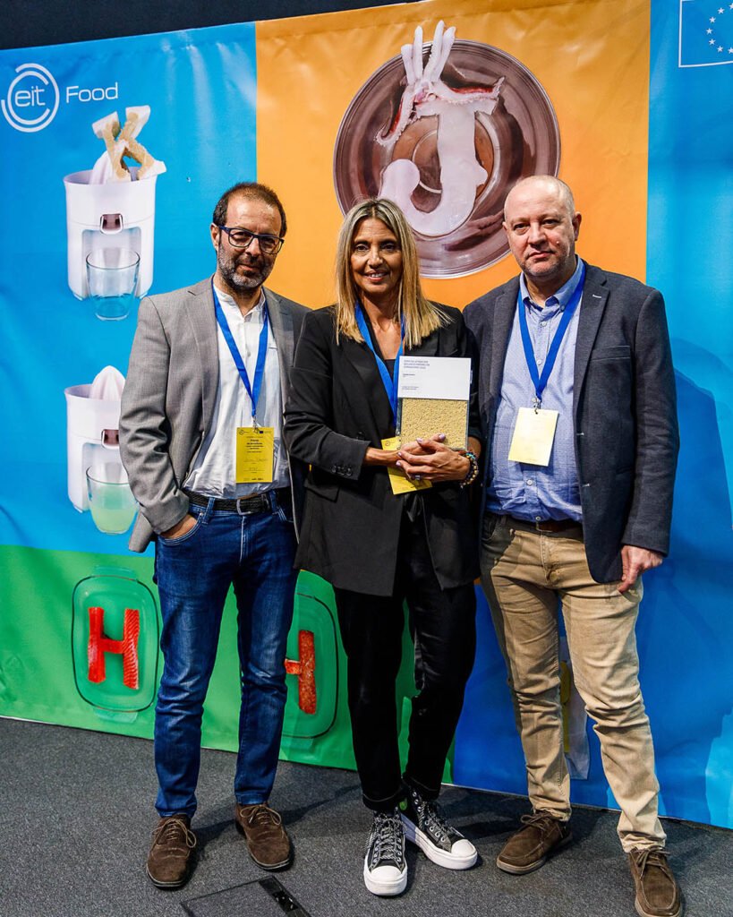 Três pessoas posam com o prémio na cerimónia do EIT Food, em 2022