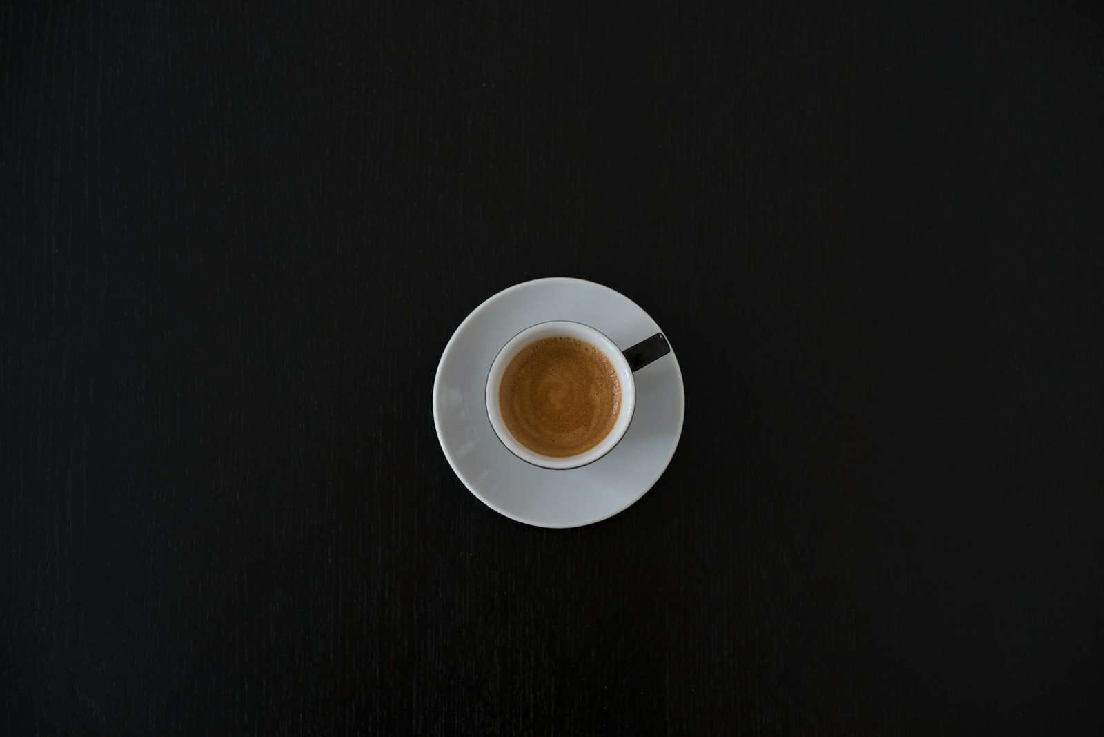 Chávena de café vista de cima sobre fundo escuro